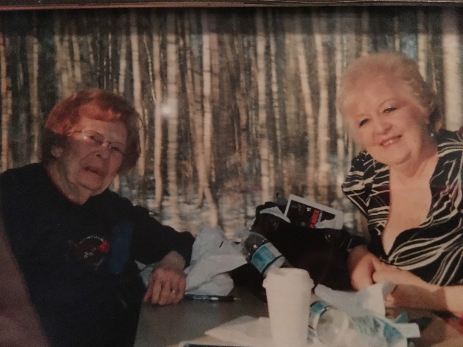 Mother Ellen and daughter Barbara sitting across each other at a kitchen table.