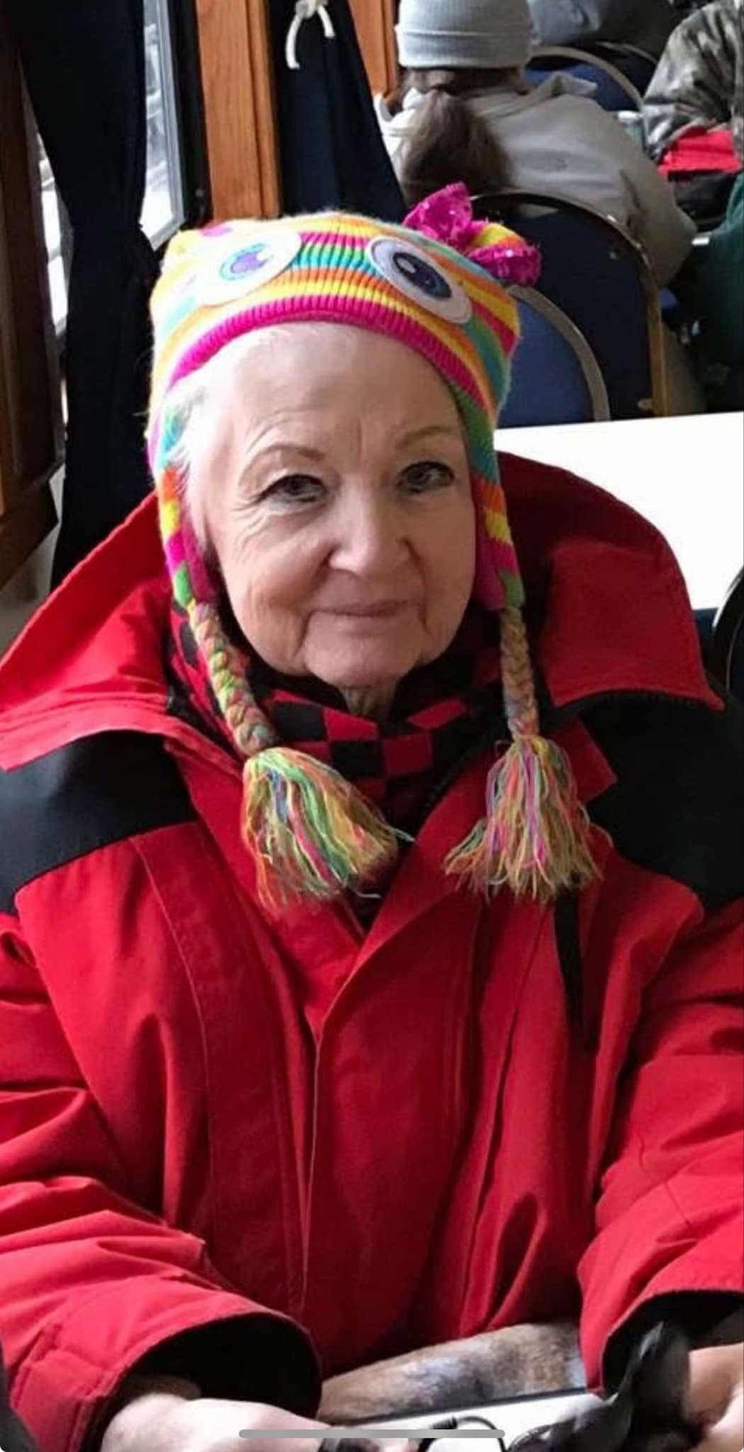 Barbara sitting down with her winter attire on smiling at the camera.