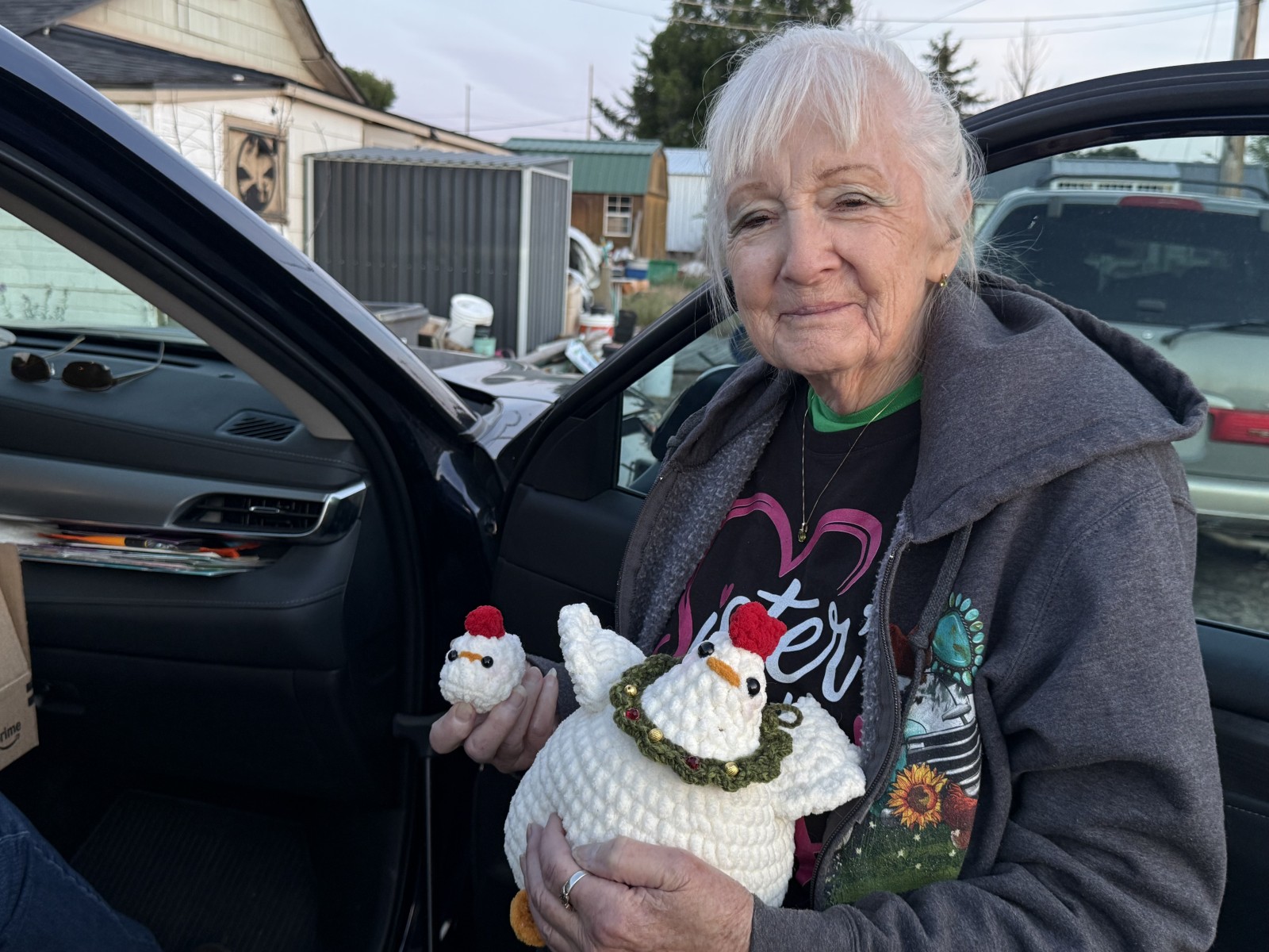 Barbara standing holding her crochet hen and chick.